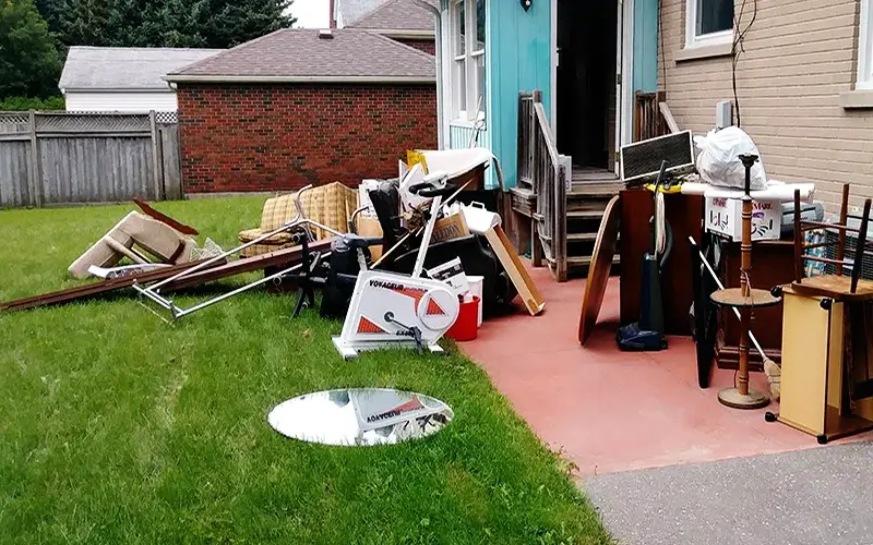 Furniture and household junk piled up at a Maine home, ready for Pine State Hauling to load and haul away