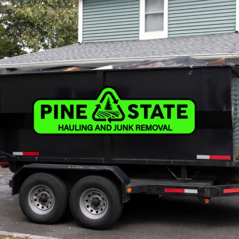 Pine State Hauling's branded dump trailer on site for a construction debris removal job in Maine